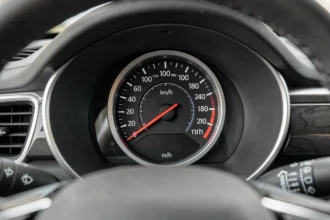 Tableau de bord de voiture affichant un compteur de vitesse avec double échelle km/h et mi/h